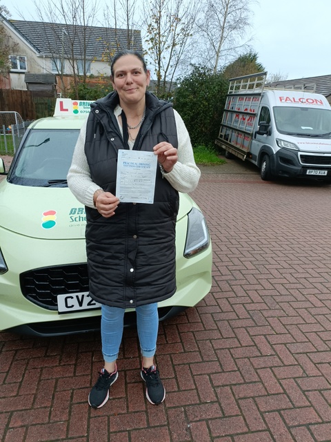 Woman in her 40s holding her driving test pass certificate in front of the car. Woman in her 40s holding her driving test pass certificate in front of the car.