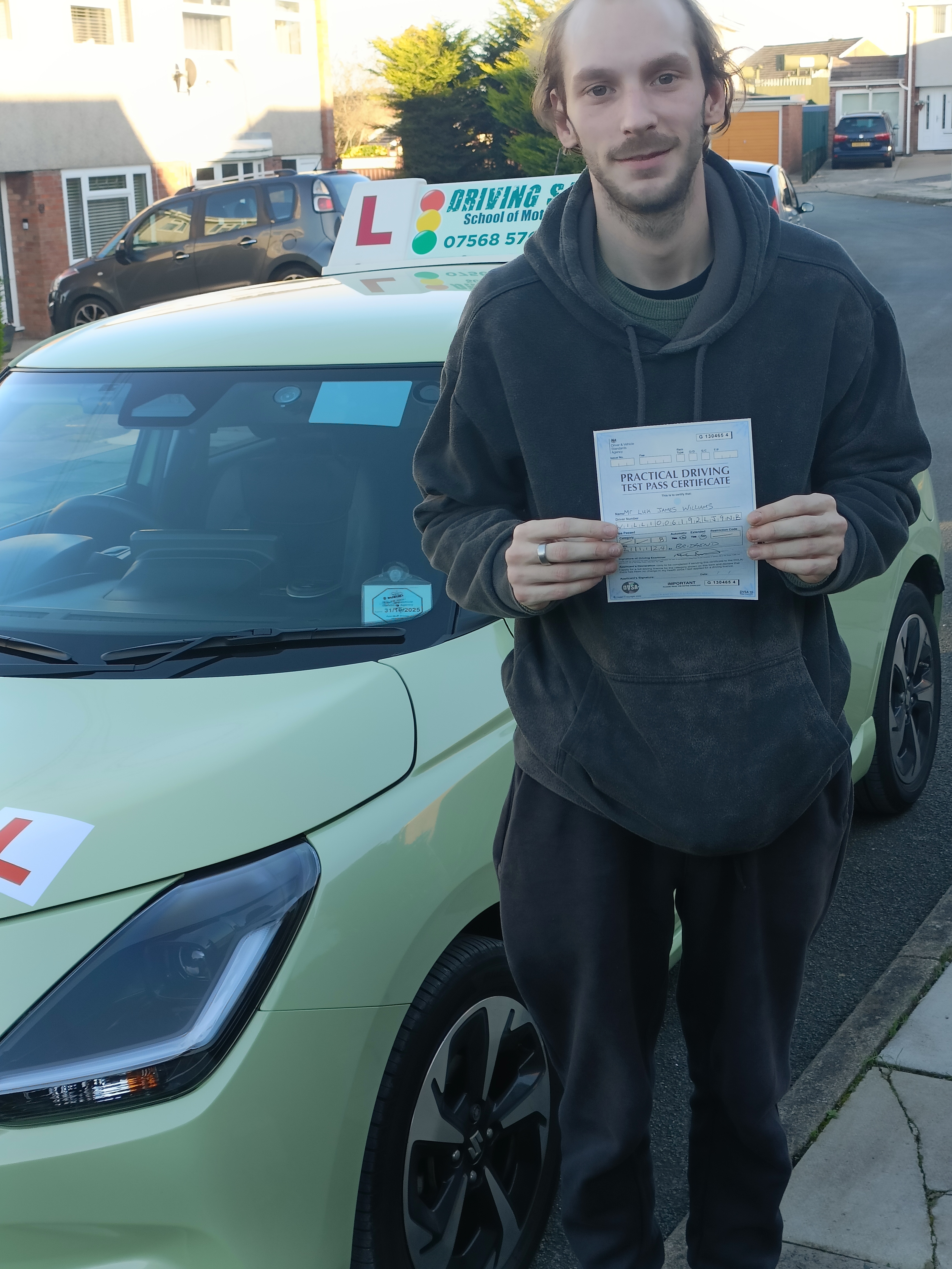 Learner driver smiling and holding a driving test pass certificate in Bridgend after lessons with Driving Safe School of Motoring Learner driver smiling and holding a driving test pass certificate in Bridgend after lessons with Driving Safe School of Motoring