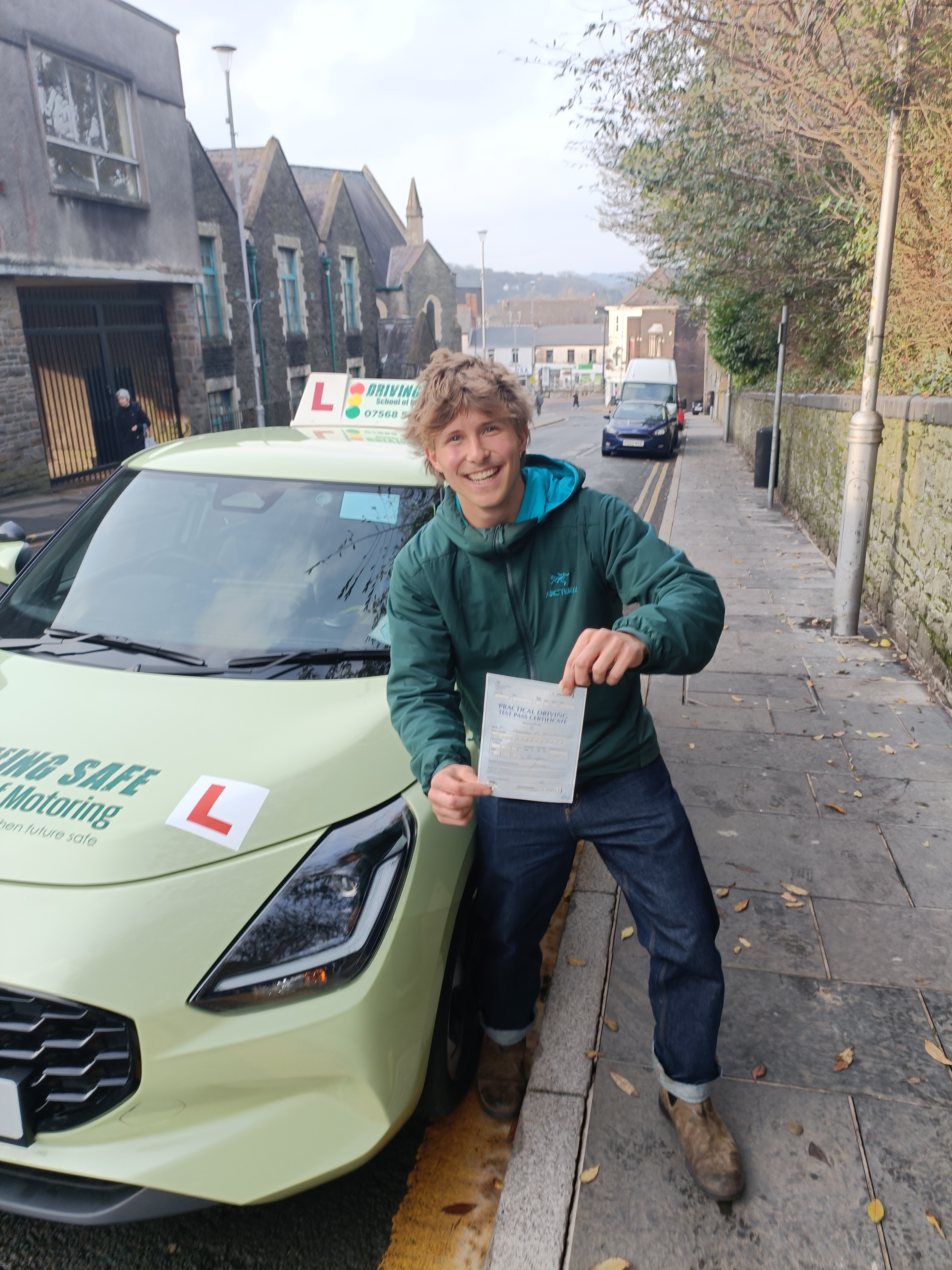 Learner driver smiling and holding a driving test pass certificate in Bridgend Learner driver smiling and holding a driving test pass certificate in Bridgend