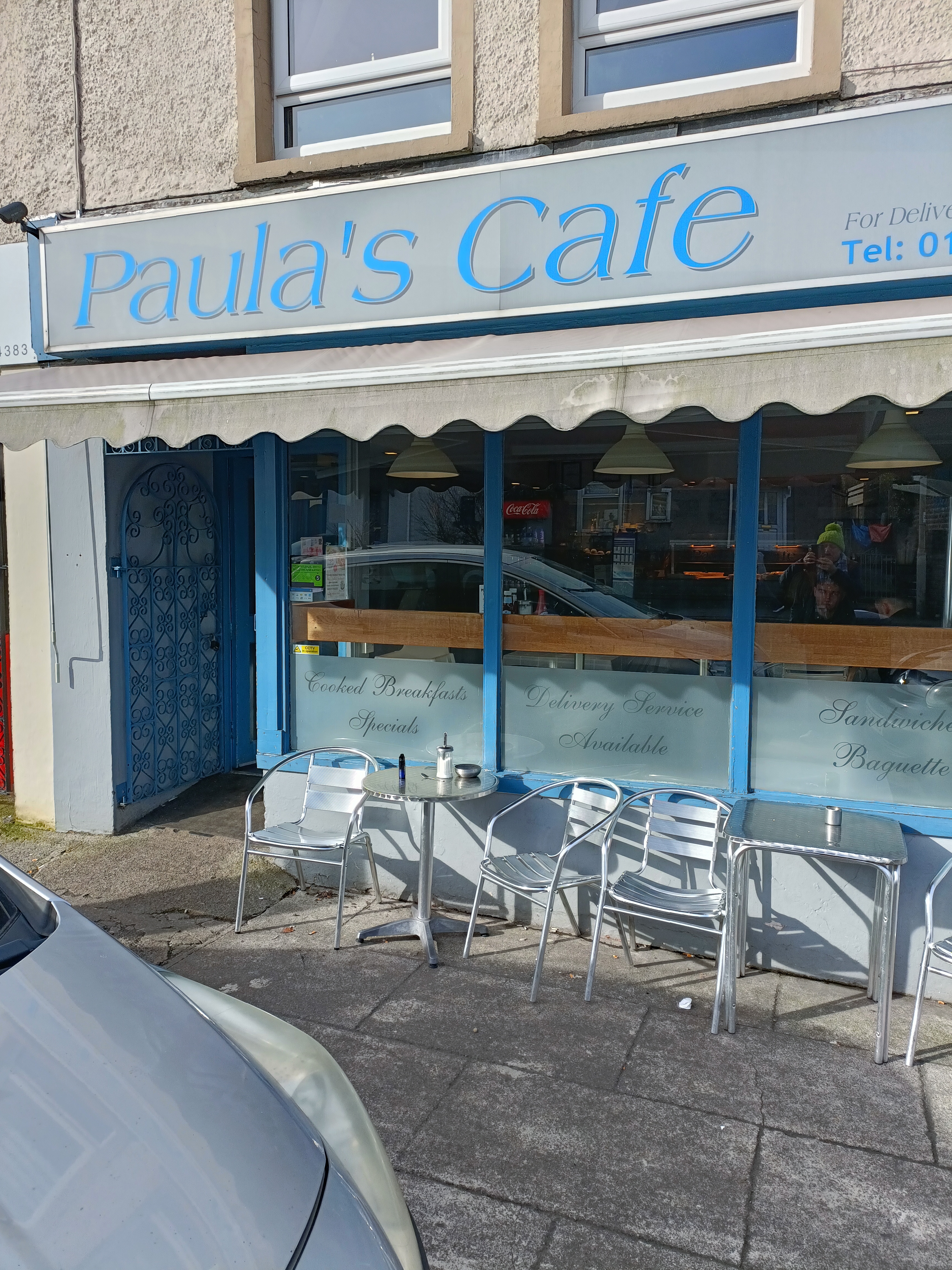 Exterior of Paula’s Café with tables and chairs outside the shop front. Exterior of Paula’s Café with tables and chairs outside the shop front.