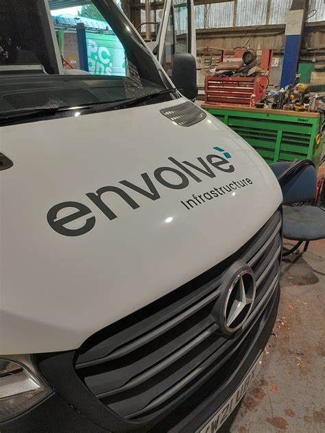 PC Signs workshop team applying new signage to the front of a white Mercedes van PC Signs workshop team applying new signage to the front of a white Mercedes van